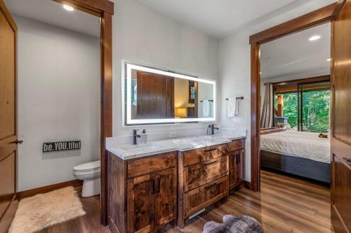 a bathroom with a sink and a toilet and a mirror at Cabin at the Crest in Ronald