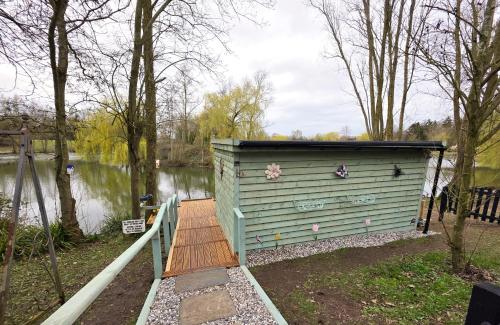 a smallshed sitting next to a body of water at The Hideaway Pod in Chelmsford