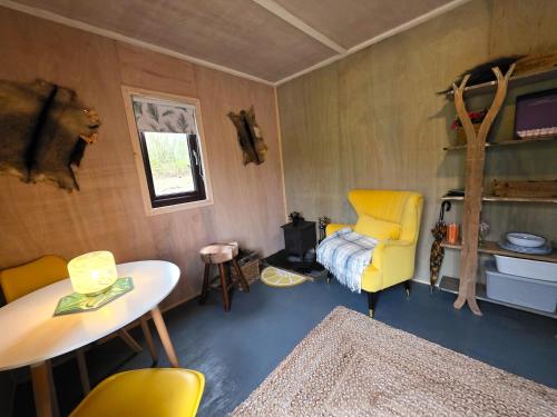a room with a table and a yellow chair at The Hideaway Pod in Chelmsford