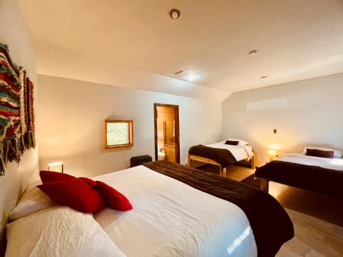 a hotel room with two beds and a mirror at Curahuapi Refugio de Montaña in Las Trancas