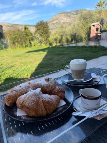 a table with two plates of pastries and a cup of coffee at Artemide Resort, Suite Spa Elysia in Lido Di Fondi