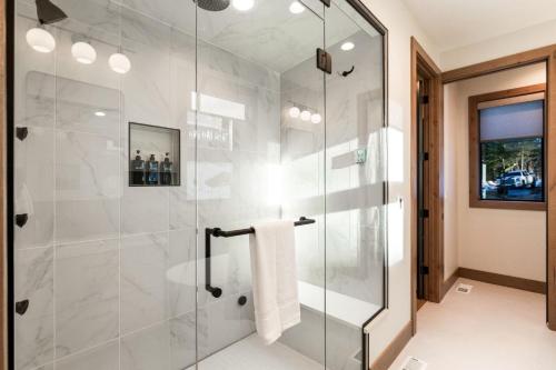 a bathroom with a shower with a glass door at Whispering Woodland in Cle Elum