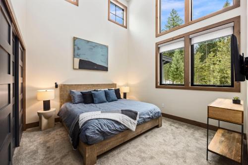 a bedroom with a bed and two windows at Whispering Woodland in Cle Elum