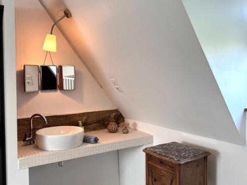 a bathroom with a sink on a counter under a roof at Maison XVIIIe avec vue panoramique exceptionnelle - 12 pers au coeur du Pays d'Auge in Le Renouard