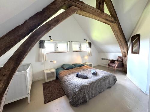 a bedroom with a large bed in a attic at Maison XVIIIe avec vue panoramique exceptionnelle - 12 pers au coeur du Pays d'Auge in Le Renouard