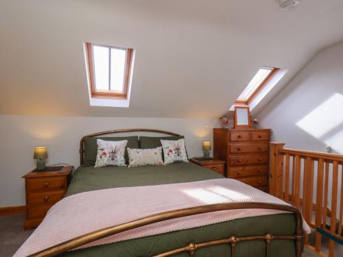 a bedroom with a bed and two skylights at Farm Yard Cottage in Pickering