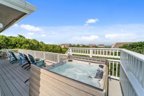 a hot tub on a deck with chairs at 2444 - Sea Forever in Duck