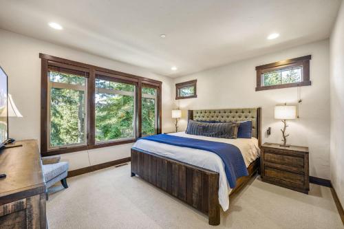 a bedroom with a bed and a desk and windows at 281 Big Rock in Cle Elum