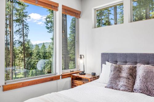 a bedroom with a bed and large windows at Three Pines in Cle Elum