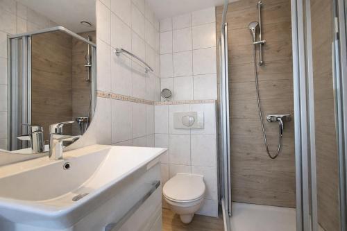a bathroom with a toilet and a sink and a shower at Fewo Lee in Kühlungsborn