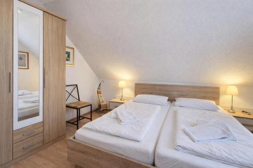 a bedroom with a large bed with white sheets at Fewo Lee in Kühlungsborn