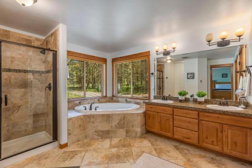 a bathroom with two sinks and a tub and a shower at Playground in the Pines in Ronald
