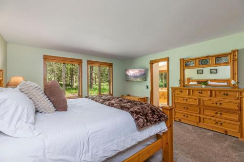 a bedroom with a bed and a dresser with a mirror at Playground in the Pines in Ronald