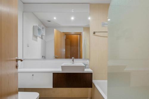a bathroom with a white sink and a mirror at Tamariz Flat in Santa Cruz