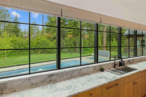 a kitchen with a large window overlooking a swimming pool at Humble House in Cle Elum