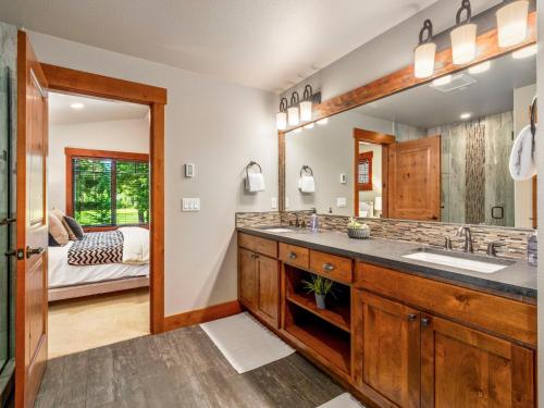 a bathroom with two sinks and a large mirror at Gilden Glade Sanctuary in Cle Elum