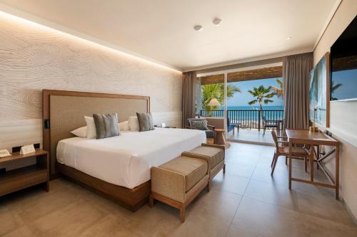 a bedroom with a bed and a view of the ocean at Punta Sal Suites & Bungalows Resort in Canoas de Punta Sal
