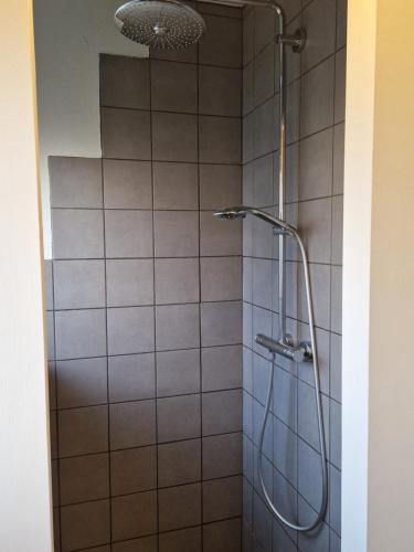 a shower with a shower head in a bathroom at SelfossCenter flat in Selfoss