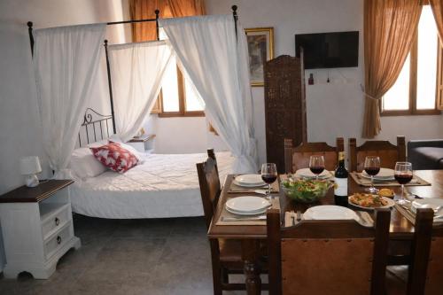 a dining room with a table and a bed at Casa di Aonio Paleario in Colle di Val d'Elsa