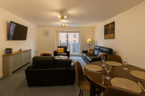 a living room with a couch and a table at Waterfront Walk 3 Bedroom Apartment with Parking Pets and Workspace in Dundee