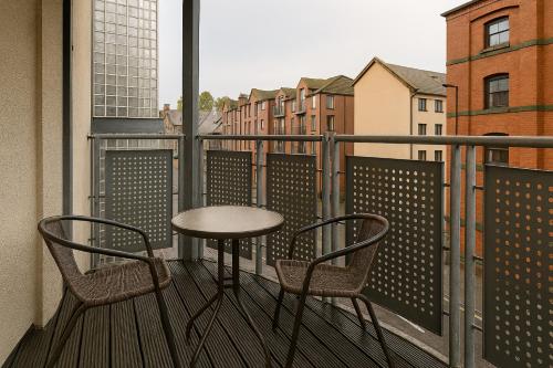 a table and two chairs on a balcony with a view at Waterfront Walk 3 Bedroom Apartment with Parking Pets and Workspace in Dundee