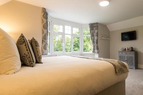 a bedroom with a large bed with a large window at The Maple Manor Hotel and guest holiday parking in Crawley