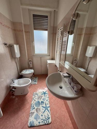 a bathroom with a sink and a mirror and a toilet at appartamento la conchiglia in Rapallo