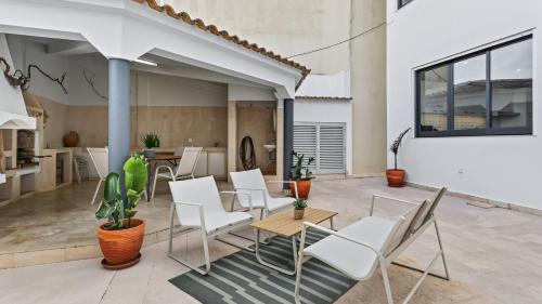 a patio with white chairs and a table at Loulé Sunny Retreat by LovelyStay in Loulé