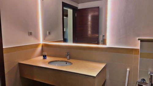a bathroom with a sink and a mirror at One Constitution Avenue by Goldfinch, Luxury apartments near Diplomatic Enclave and Serena in Islamabad