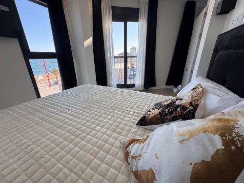 a bedroom with a large bed with a large window at MINA MAR 1ª línea playa ADULTS ONLY in Vinarós