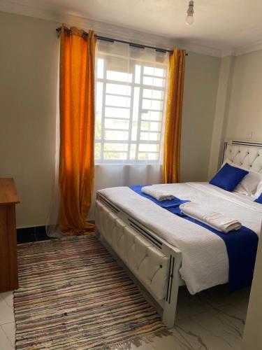 a bedroom with a large bed and a window at Blissful Homes in Thika