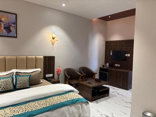 a hotel room with a bed and a tv at Hotel Blue Ocean in Bharweli