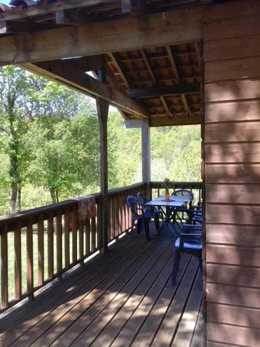 a wooden deck with a table and chairs on it at ZEcamping 3 étoiles avec piscine et pataugeoire in Saint-Projet