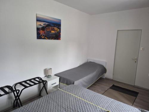 a room with two beds and a picture on the wall at Solmar Adriatica Apartman in Banjole