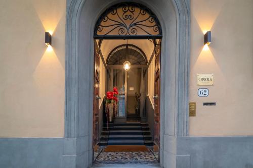 an entrance to a building with a stairway with red flowers at Opera Boutique B&B in Florence