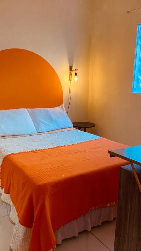 a large bed with an orange headboard in a room at Bossa Nova Home in Barra dos Coqueiros