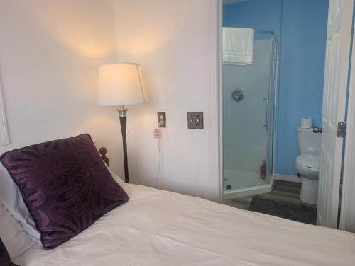a bedroom with a bed with a purple pillow on it at Calgary Star Cozy Home in Calgary