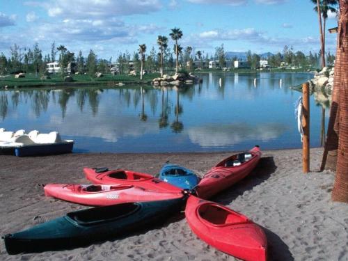a group of three kayaks on the shore of a lake at RV Park at Lakeside Casino in Pahrump