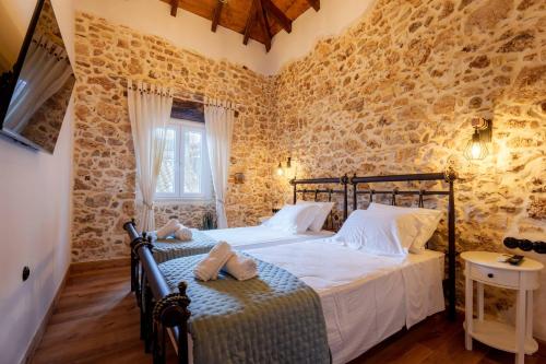 ein Schlafzimmer mit einem Bett in einem Raum mit Steinwänden in der Unterkunft Lithari Suites in Sokrákion
