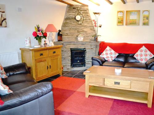 a living room with two couches and a fireplace at Fordbrook Cottage in Brixton