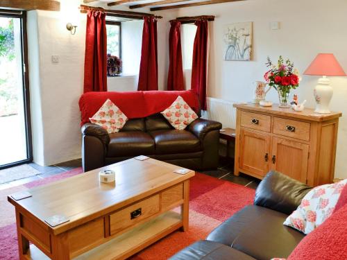 a living room with a couch and a coffee table at Fordbrook Cottage in Brixton