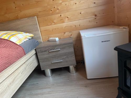 a bedroom with a bed and a small refrigerator at Sleep-box Radwerk 14 in Vordernberg