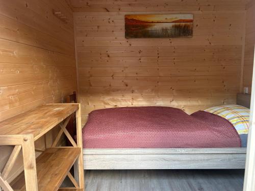 a small room with a bed in a wooden cabin at Sleep-box Radwerk 14 in Vordernberg