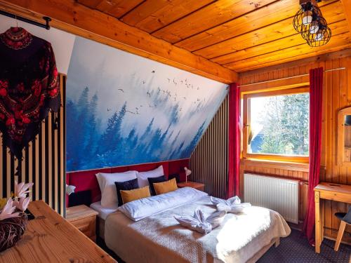 a bedroom with a bed and a painting on the wall at LookTatry Willa Pod Stokiem Apartments & Jacuzzi in Zakopane