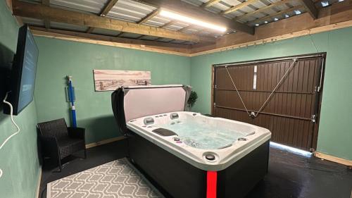 a bath tub in a room with a horse stall at Romantic getaway with private hot tub in Belfast