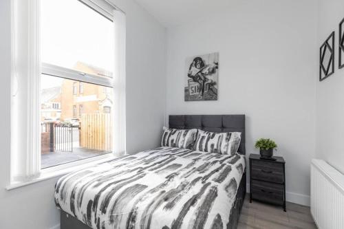 a white bedroom with a bed and a window at Romantic getaway with private hot tub in Belfast
