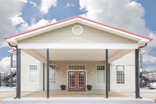 a white building with a red door at Super 8 by Wyndham Talladega AL in Talladega