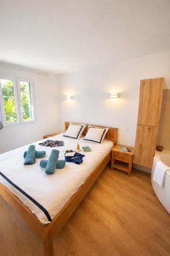a bedroom with a large bed with blue pillows at BERGERIE PLAGE 5 personnes Rénové avec climatisation et bain à remous in Hyères