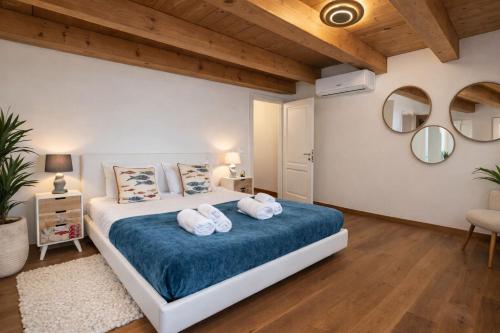 ein Schlafzimmer mit einem großen Bett, auf dem Handtücher liegen in der Unterkunft Greif Boutique Juna in Aurisina