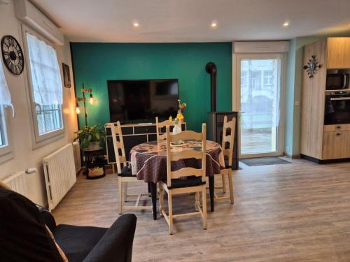 a dining room with a table and a green wall at Ti Ar Skol, chambre d'hôtes in Huelgoat